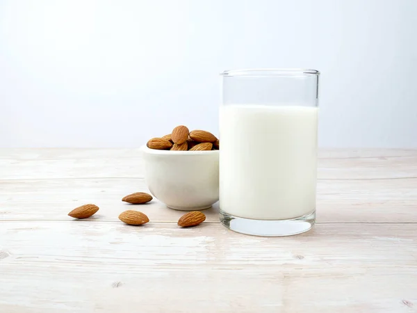 stock image Almond milk on wooden texture background.