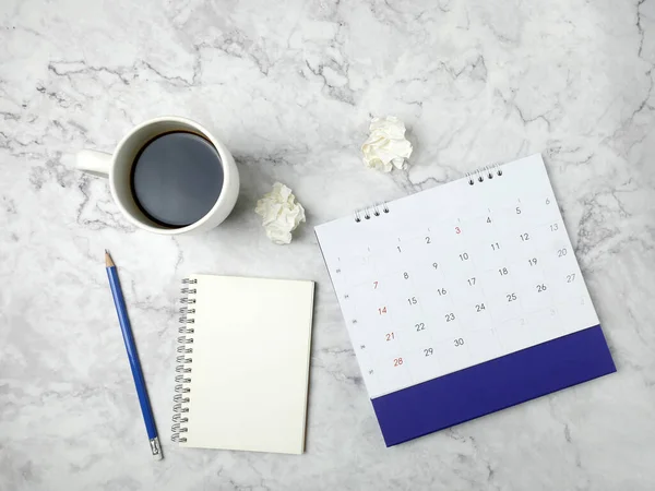 stock image Calendar with coffee cup on marble texture background.