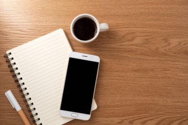 Boş model ekranlı cep telefonu ve ahşap dokular üzerine kitap. Çalışma masası. Üst Manzara. düz yat.