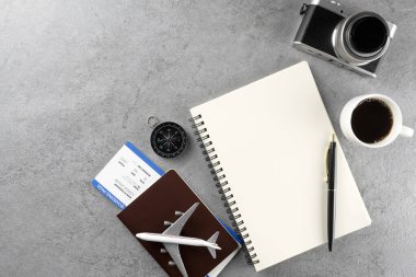 Pasaport, giriş kartı, not defteri ve kamera, taş dokunun arka planında. Turizm ve seyahat konsepti. Üst Manzara. Düz yatıyordu.