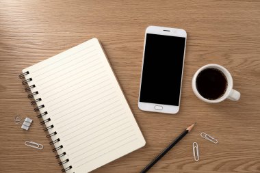 Boş model ekranlı cep telefonu ve ahşap dokular üzerine kitap. Çalışma masası. Üst Manzara. düz yat.