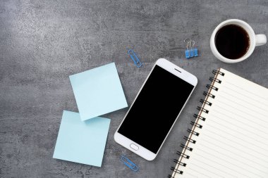 Cep telefonu, boş bir ekran ve taş dokusu üzerine bir kitap. Çalışma masası. Üst Manzara. Düz yatıyordu.