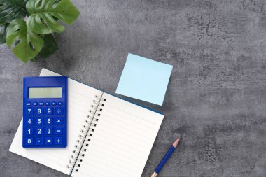 Kaya dokusu arka planında hesap makinesi ve defter. Tam bir iş yeriydi. Muhasebe işyeri konsepti. En üstteki görünüm.