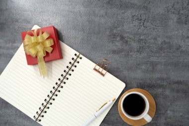 Arkaplanda not defteri ve kahve olan bir hediye kutusu. Planlama. Düz yatıyordu. Üst görünüm.