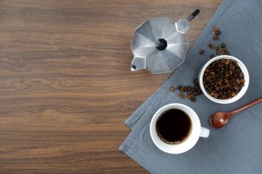 Kahve fincanı ve kahve çekirdekleri ahşap masada. Metniniz için metin alanı olan üst görünüm