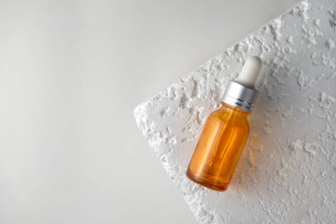 Taş beyaz zemin üzerinde damla şişesi, minimal stil Güzellik ürünleri paketleme taklit