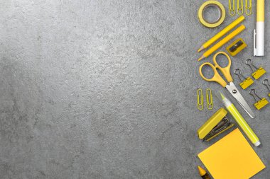 Taş dokusu arka planında sarı kırtasiye malzemesi. Çalışma masası alanı