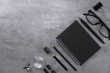 Defter ve siyah kırtasiye malzemesi. Çalışma masası alanı