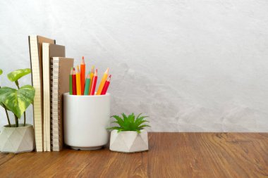 Defter ve kalem bardağı masanın üstünde. Çalışma masası alanı