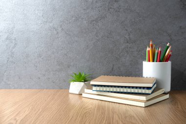 Defter ve kalem bardağı masanın üstünde. Çalışma masası alanı