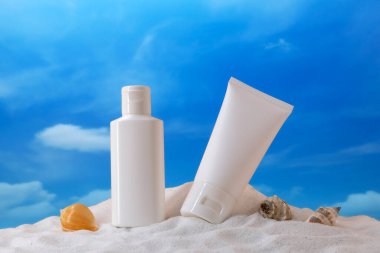 Krema tüpü ve kabuklar kumun üzerinde. Model için kozmetik ürün