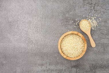 Kaşık içinde beyaz susam. Arka planda taş desenli kâse var.