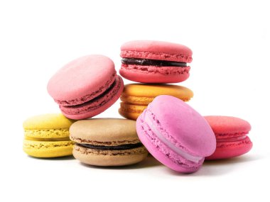 Beyaz arka planda izole edilmiş çeşitli tat ve renklerde makarna kurabiyeleri yığını.