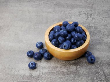 Yaban mersinleri ahşap kasede taş desenli arka planda