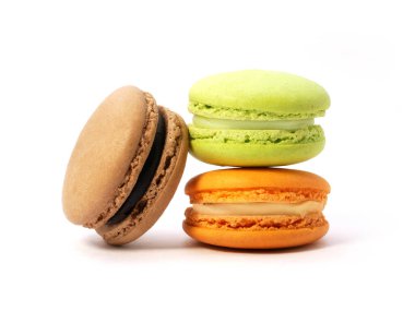 Beyaz arka planda izole edilmiş çeşitli tat ve renklerde makarna kurabiyeleri yığını.