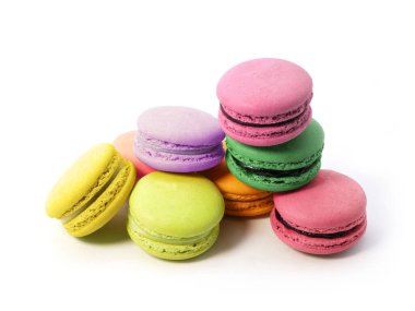 Beyaz arka planda izole edilmiş çeşitli tat ve renklerde makarna kurabiyeleri yığını.