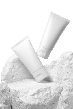 Beyaz arka planda izole edilmiş taşlı beyaz plastik krema tüpü. Seçici Odaklanma.