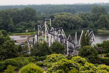 Hollanda, Biddinghuizen - 15 Temmuz 2014 - Bir göl yakınlarındaki yemyeşil bir hız treninin havadan görünüşü. Altlık, ağaçlar ve park alanlarıyla çevrili siyah raylı ve beyaz destekli eşsiz bir tasarıma sahip..