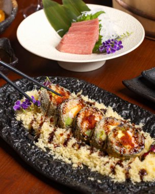 Bir Japon restoranında suşi yapma sanatını keşfedin. Çok güzel yapılmış suşi ruloları ve taze sashimi sosu sergiliyorsunuz..