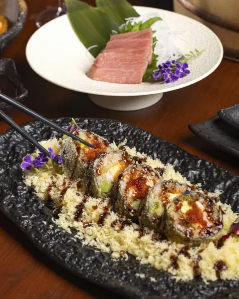 Bir Japon restoranında suşi yapma sanatını keşfedin. Çok güzel yapılmış suşi ruloları ve taze sashimi sosu sergiliyorsunuz..