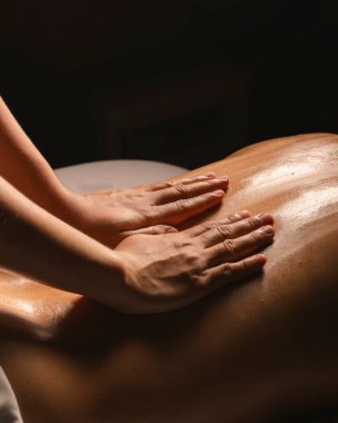 Rahatlamak ve stres atmak için mükemmel sakin bir spa ortamında masaj seansının sakinliğini hissedin..