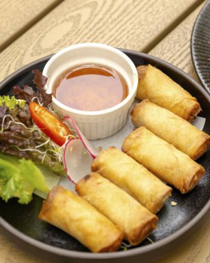 Sıcacık bir restoran atmosferinde sunulan tatlı soslu böreklerin tadını çıkarın..