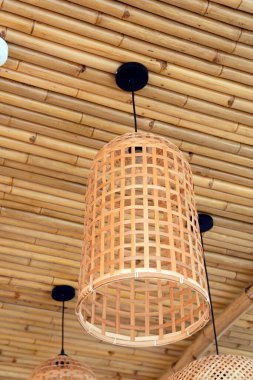 Bambu duvarında asılı yapışkan rattan lamba.