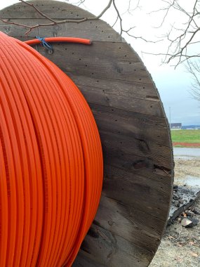 İnşaat alanında turuncu kabloyla ahşap bir makara. Yan görünüm kapat