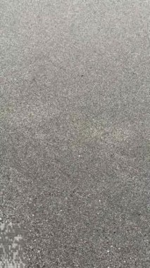 Islak kumlu bir sahil sakin okyanus dalgalarına dönüşüyor. Doğal bir arka plan. Dokular, doğa sahneleri ya da rahatlatıcı bir atmosfer için mükemmel. Marbella, İspanya.