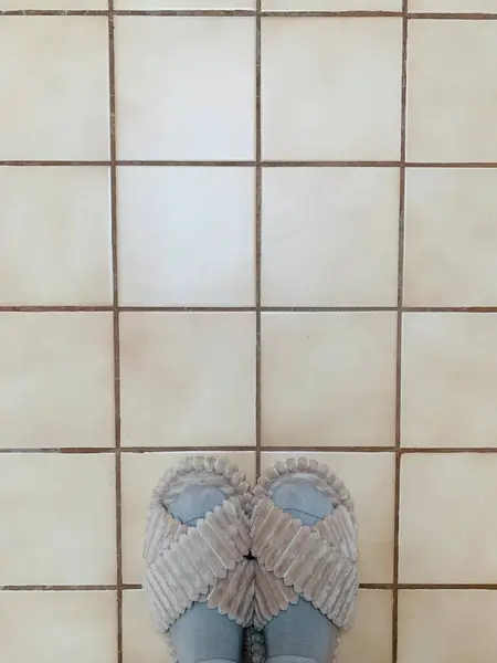 Bej döşeme üzerinde rahat terlikler ve çoraplar. Minimalist bir iç mekanda sıcaklık ve rahatlık. Rahat ve konforlu bir atmosfer..