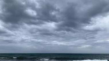 Marbella, Endülüs, İspanya sahillerinde bulutlu bir gün. Dalgalar kıyıya vururken dramatik gri gökyüzünün altında