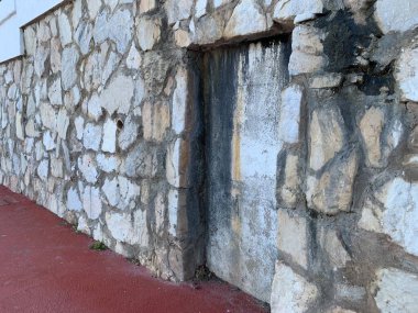 İspanya, Endülüs 'teki taşra cephesinde gizemli bir kapalı kapı ya da duvar arası. Eskimiş dokular ve yıpranmış detaylar esrarengiz cazibesine katkı sağlıyor. Yan görünüm