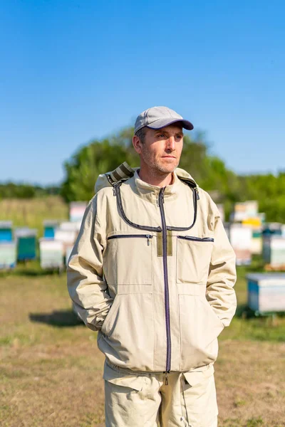 夏の蜂蜜農業の愛国者 男で保護養蜂スーツでApiary — ストック写真