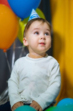 Bebeklerin ilk doğum günü. Renkli balonları olan bir yaşında. Mutlu bebek doğum gününü kutluyor..