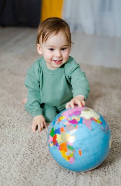 Coğrafi küresi olan bebek çocuk. Dünyayı keşfeden çocuk