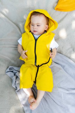 Parkta battaniyeye uzanmış şirin bir çocuk. Çocuklar için dışarıda eğlence.