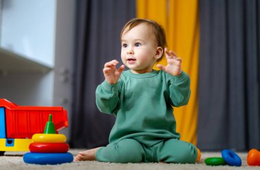 Renkli gökkuşağı oyuncak piramidiyle oynayan şirin bir bebek. Küçük çocuklar için oyuncaklar. Küçük çocuk yuvası için iç mekan. Eğitici oyuncağı olan çocuk. Erken gelişme.