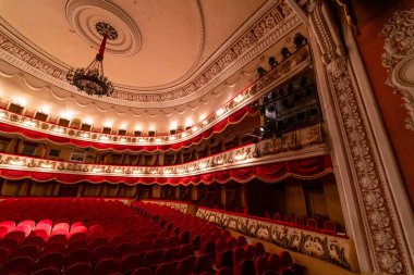 The interior of Central Golden Hall in empty theater with red seats and balcony. Luxurious theater hall in classic baroque style.