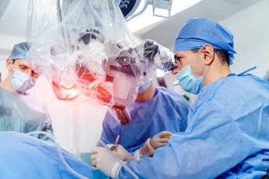 Mikroskopla operasyon. Cerrahlar ameliyat sırasında tıbbi aletler kullanırlar. Uzmanlar modern ameliyathanedeki mikroskopu inceliyor..