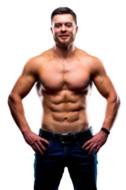Muscular guy with naked torso posing with hands on waist. Portrait of a handsome man in jeans isolated on white studio background