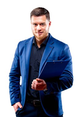 Half-length portrait of handsome young smiling man wearing dark shirt and blue suit holding blue folder, looking at camera. White background. Money and business concept.