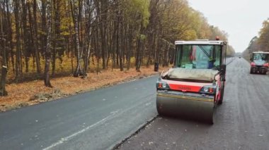 Buharlı silindirle yolun solunumu. Yol yapımı paten sıkıştırma makinesiyle çalışıyor