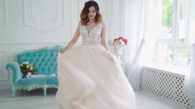 Gelin stüdyoda poz veriyor. Gelinin güzel portresi, şık bir gelinlik, makyaj ve saç stili, stüdyo manzaralı.