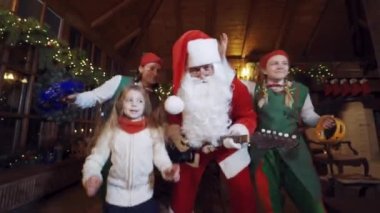 Mutlu Noel Baba ve çocuklar. Noel Baba çocuklarla ve elflerle dans ediyor.