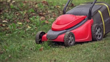 Çim biçme makinesi. Çimleri biçen adamın yakın görüntüsü