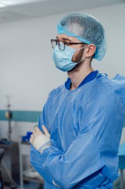 Üniformalı acil servis uzmanı. Steril maskeli doktor ameliyat hastanesinde çalışıyor..