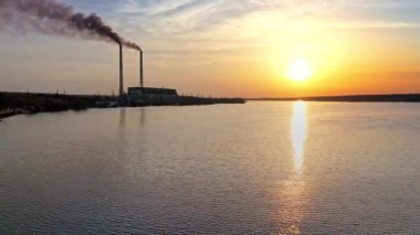 Yansıma nehri olan günbatımı bulutları. Gün batımında nehir kıyısında manzara