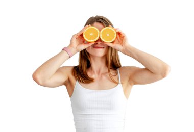 Young woman preparing tasty lemonade isolated on a white background. Detox diet. Healthy Nutrition. Holding orange halves near eyes