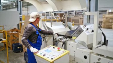 Man work at modern factory Worker in protective clothing in factory using machine