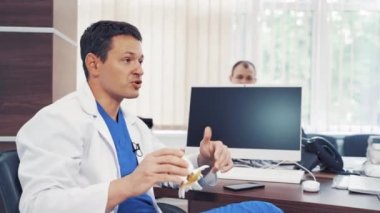 Doktor danışmanlık yapıyor. Doktor muayenehanesinde kadın hastayla konuşuyor.